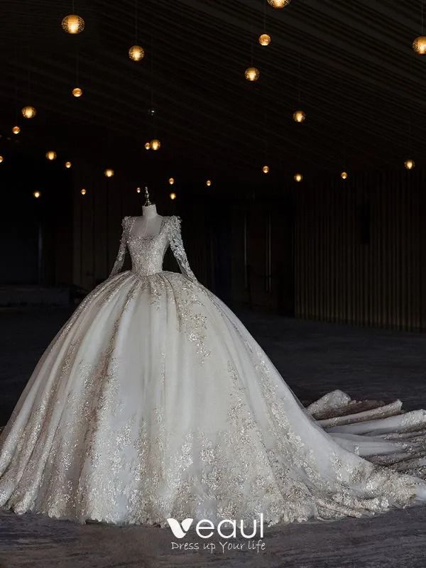 a wedding dress is displayed in an empty room with lights hanging from the ceiling above it