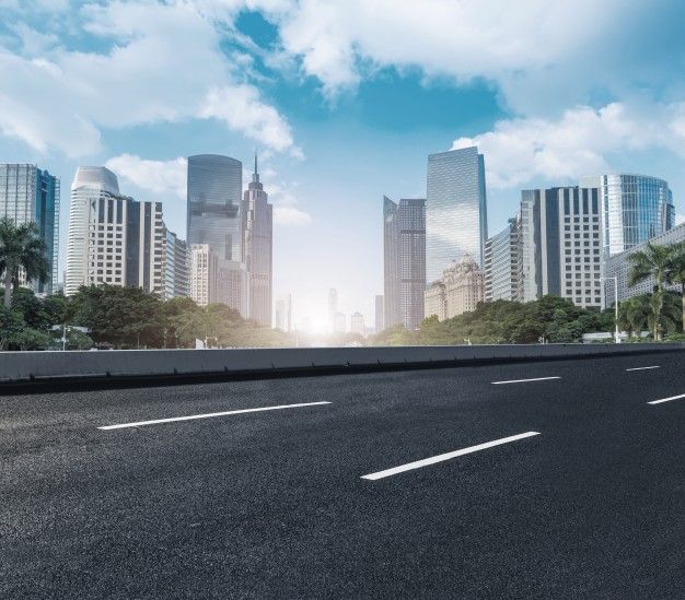 an empty street with tall buildings in the background