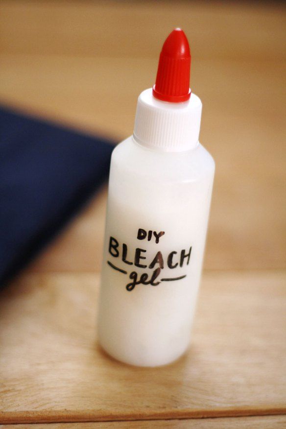 a small bottle with a red cap sitting on top of a wooden table