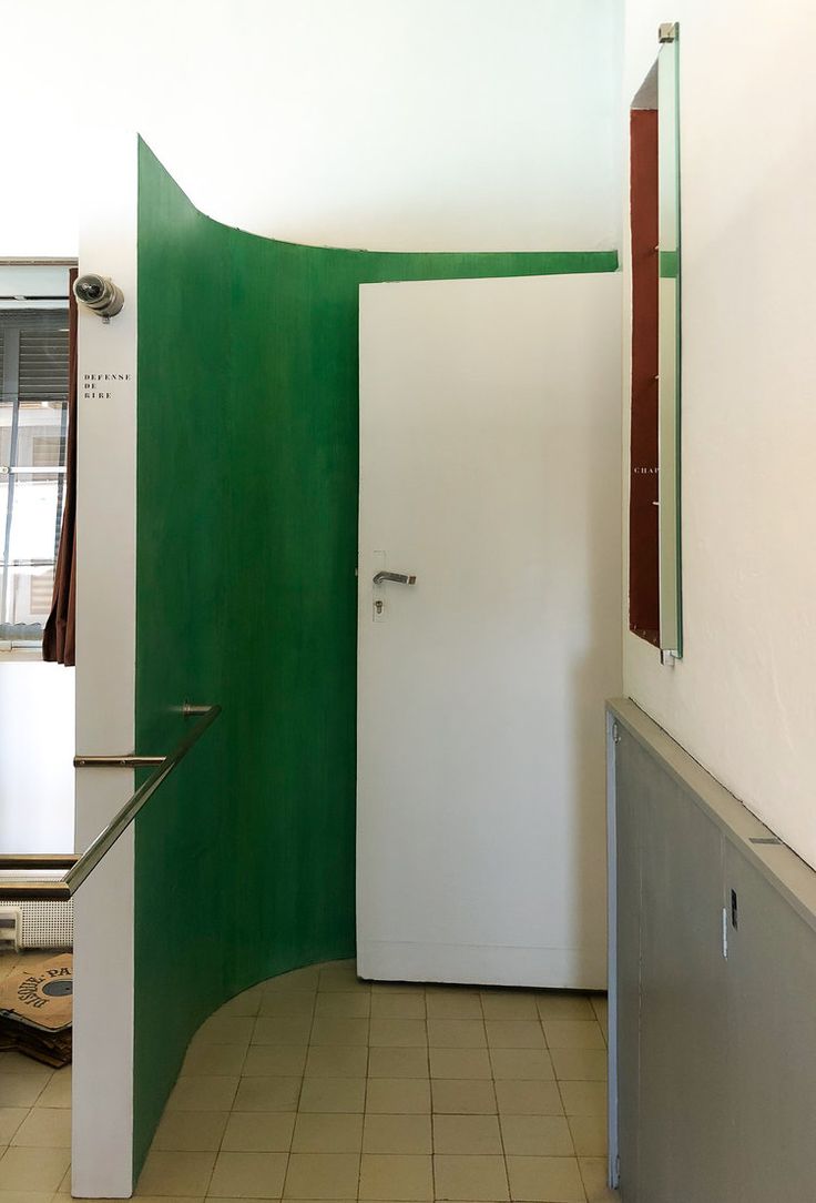 an empty room with a green door and tiled floor