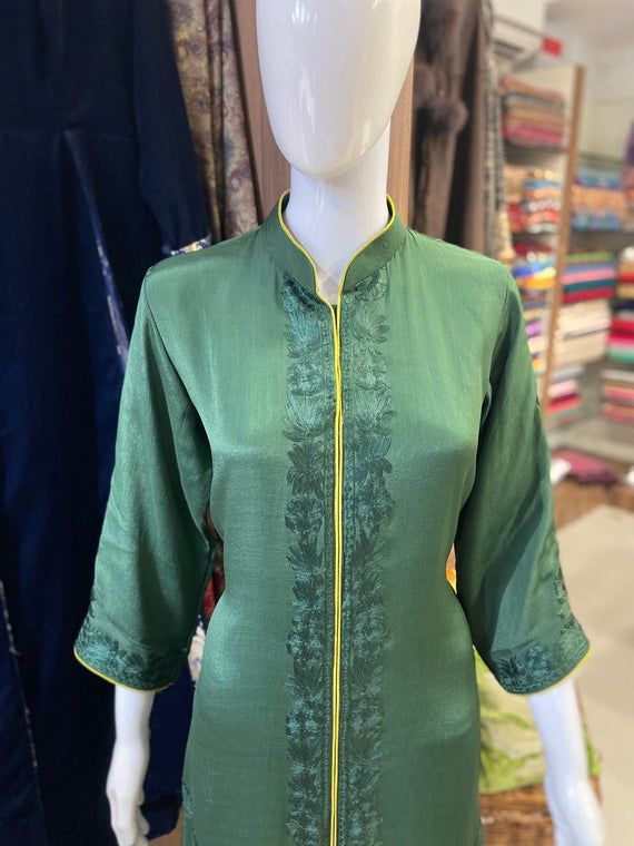 A stunningly marvellous outfit featuring Kashmiri Aari embroidery. - - - - - - - - - - - - - - - - - - - - Product Details- Condition: Brand New (made to order)– Handmade– Style: Indian Ethnic Suit– Embroidery: Kashmiri Aari Work with Silk Thread- Colour: Bottle & Lime Green– Care Instructions: Dry Clean OnlyF A B R I CShirt: ChinonDupatta: ChinonLower: Indian CrepeF I N I S HUnstitched/Semi-StitchedYou can get it stitched locally.47+ inches of Shirt Length and up to full sleeves length.Stitched Cotton Silk Sharara With Embroidered Border For Festivals, Festival Cotton Silk Sharara With Embroidered Border, Green Cotton Silk Traditional Wear With Resham Embroidery, Green Silk Kurta With Embroidered Border, Silk Kurta With Resham Embroidery For Diwali, Green Silk Anarkali Set With Embroidered Border, Traditional Cotton Silk Sharara With Embroidered Border, Green Cotton Silk Kurta With Zari Work, Green Zari Work Kurta In Cotton Silk