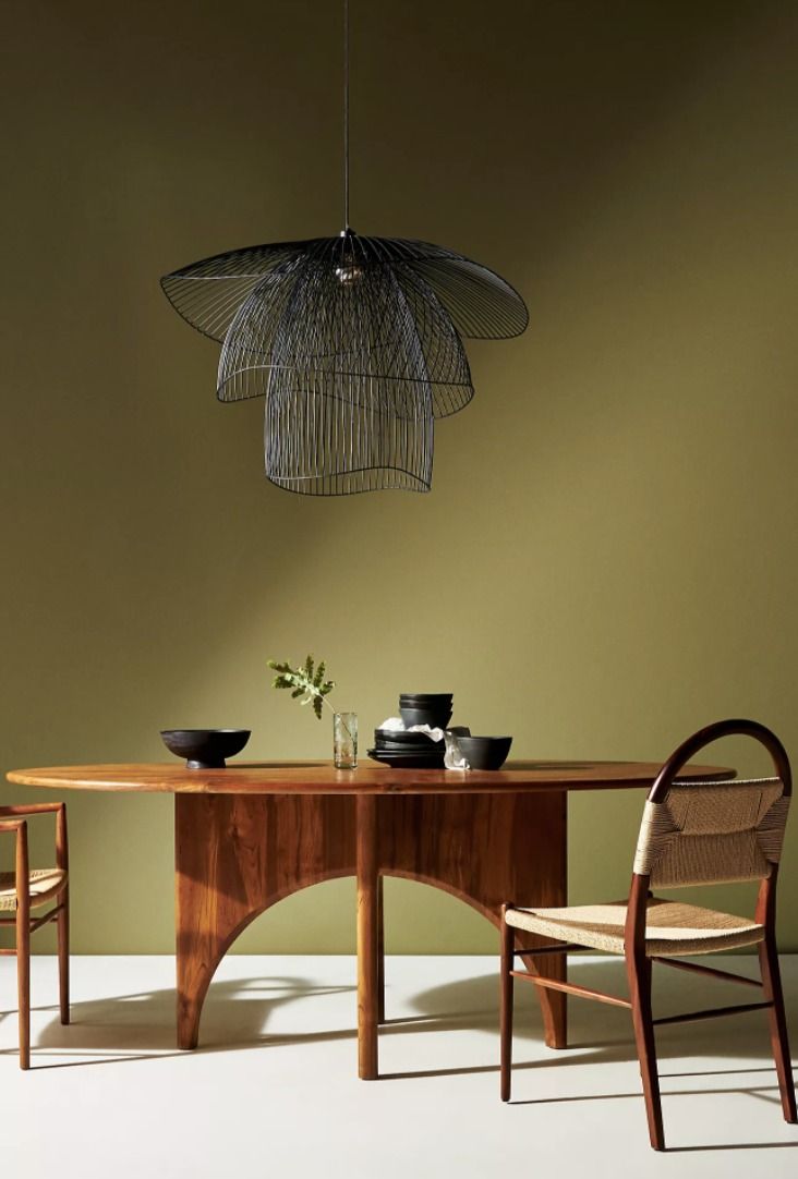 a wooden table with two chairs and a light hanging from the ceiling