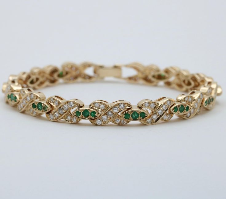 Fiery diamonds and vibrant emeralds are combined in this romantic XO design bracelet modeled in gleaming 14K gold.  Each of the X links are set with diamonds weighing a total of approximately 3.5 carats, mostly G/H/I in color and SI in clarity.  The "O" links are set with emeralds weighing approximately 1.44 carats.  Solidly constructed, this bracelet weighs 20 grams and measures 6.8 inches long.  A gorgeous piece to add to any jewelry collection! Metal: 14K Yellow Gold (acid tested) Weight: 20 grams Diamonds: Approx. 3.5 cts Emeralds: Approx. 1.44 cts Measurements: 6.8 inches by 6.5 mm wide  Markings: None Condition: In good vintage condition with some surface wear to a few emeralds.  Some diamonds appear to have been replaced later.  Follow us on Instagram @alphaomegajewelry for the late Gold Arm Band, Estate Diamond Jewelry, Xo Design, Design Bracelet, Gold Armband, Long A, G H, Chain Link Bracelet, Bracelet Designs