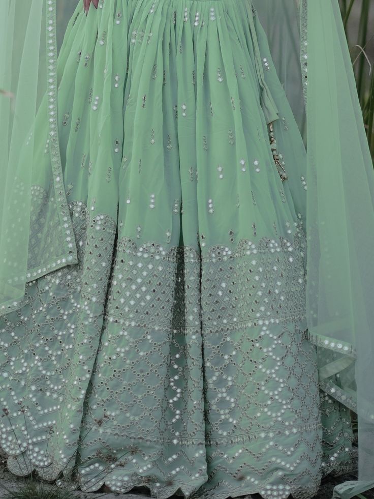 This exquisite ensemble exudes elegance and charm with its pastel green color and intricate detailing. Crafted from high-quality georgette fabric, the lehenga is adorned with zari embroidered and heavy sequin work, making it a perfect choice for weddings, receptions, engagements, and other special occasions.
The semi-stitched design allows for customization up to 42 inches, ensuring a perfect fit for every body type. The matching blouse, also made from georgette material with zari and sequin wor Pista Green Lehenga With Intricate Embroidery For Party, Green Lehenga With Intricate Embroidery In Georgette, Green Georgette Sets With Intricate Embroidery, Party Anarkali Set In Pista Green With Intricate Embroidery, Green Georgette Gown With Intricate Embroidery, Green Chinon Lehenga For Reception, Pista Green Georgette Dupatta, Green Gown With Intricate Embroidery, Green Georgette Anarkali Set With Intricate Embroidery