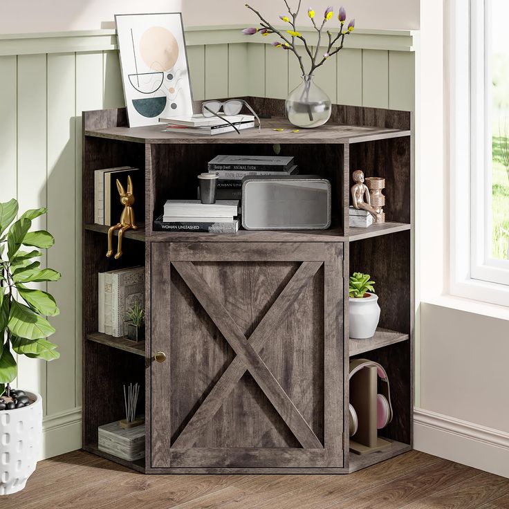 an entertainment center in a room with wood flooring and green walls, decorated with flowers