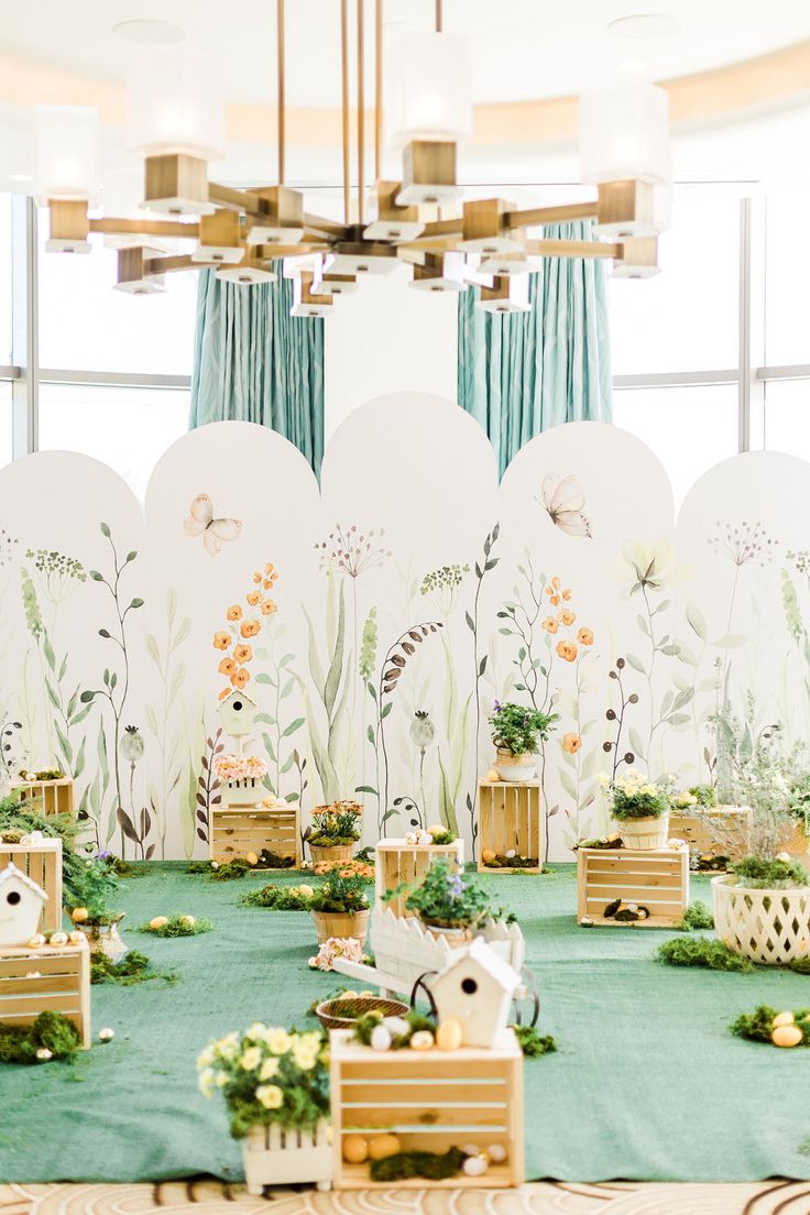 a room filled with lots of tables covered in green and white decorating items on top of wooden crates