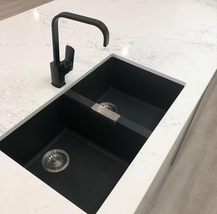 a black sink sitting on top of a white counter