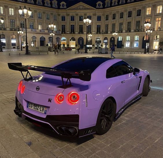 a purple sports car parked in front of a building