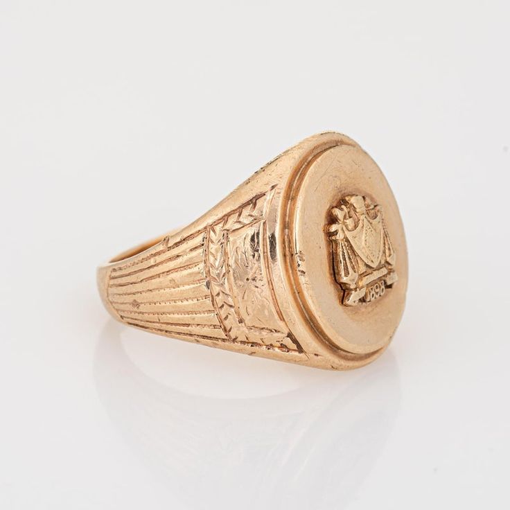 Finely detailed antique Victorian family crest signet ring (circa 1898), crafted in 10 karat yellow gold.   The oval signet mount features a family crest with the year '1898' to the base. The side shoulders feature a pretty etched foliate design. The low rise ring (3.5mm - 0.13 inches) sits comfortably on the finger.    The ring is in good condition with some wear evident. We have not cleaned it in order to preserve patina and collector value.   Particulars:  Weight: 13.5 grammes  Stones:  N/A Classic Engraved Signet Ring For Commemoration, Gold Antique Signet Ring For Commemoration, Antique Gold Signet Ring For Commemoration, Heirloom Signet Ring For Commemoration, Heirloom Round Signet Ring For Commemoration, Classic 14k Gold Signet Ring For Ceremonial Occasions, Classic Hallmarked Signet Ring For Commemoration, Formal Yellow Gold Signet Ring With Coat Of Arms, Classic Signet Ring For Commemoration