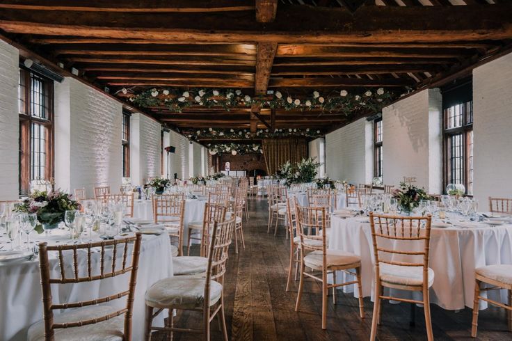 a room filled with lots of tables covered in white linens