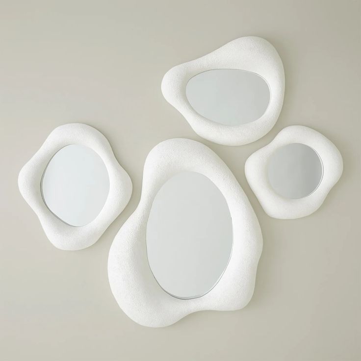 three white oval mirrors sitting next to each other