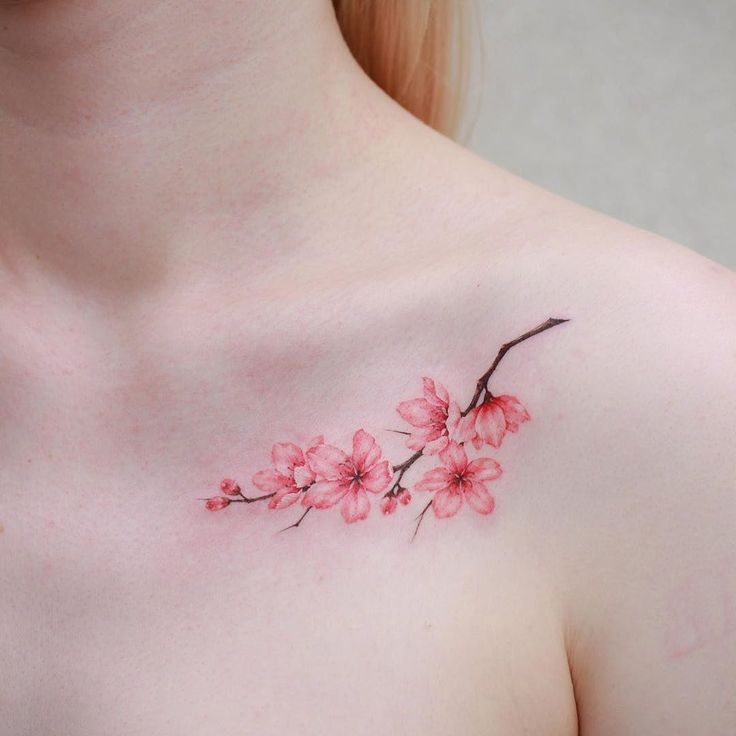 a woman's chest with pink flowers painted on the top and bottom part of her breast