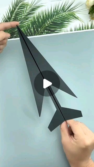 someone is cutting out an origami airplane