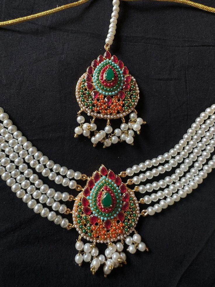 The jewelry set being offered here is a traditional Noratan bridal set, often worn during weddings or other formal occasions in Indian and Pakistani cultures. It is a multicolor set that can complement with many outfits and can be worn at many formal occasions. Here's a detailed description of this Navratan set  - **Noratan Bridal Choker The choker is  grand and intricate, typical of Noratan designs. It  features a combination different color embedded beads on a golden background.  The design is classic traditional, reflecting a regal and opulent style, perfect for a bridal ensemble. - **Matching Earrings The earrings in this set  complement the choker, dangling big statement jhumkas with a similar pattern of stones and intricate gold work. The large jhumka design add elegance and balance Traditional Wedding Sets With Latkans, Traditional Heavy Lehenga For Navratri, Traditional Eid Lehenga With Stone Work, Traditional Lehenga With Stone Work For Eid, Traditional Anarkali Set With Stone Work For Festivals, Festive Bridal Sets With Latkans For Diwali, Traditional White Chandbali Sets, Traditional Multicolor Jewelry For Traditional Ceremonies, Traditional Multicolor Jewelry For Ceremonies