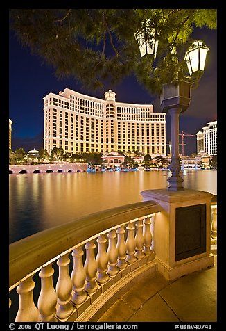 the lights are on in front of the hotel and casino buildings by the water at night