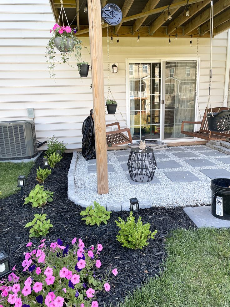 an outdoor patio with flowers and plants on the ground