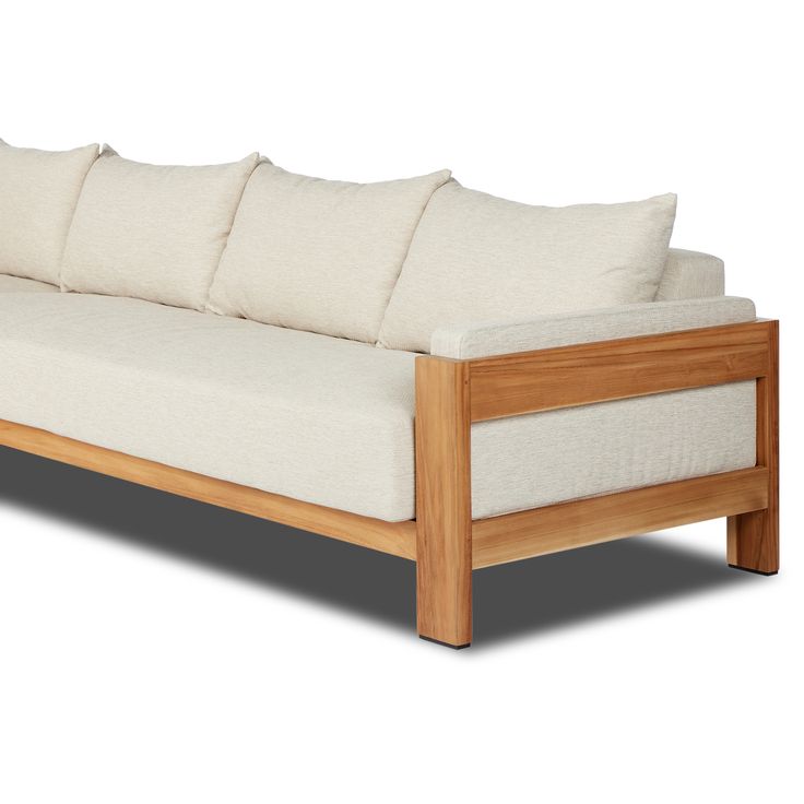 a wooden couch with four pillows on it's back and side ends, sitting against a white background