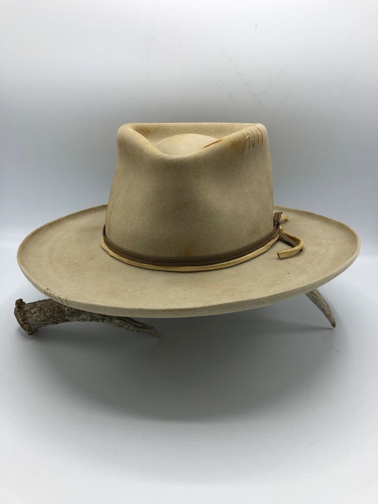 Western 50x in Sahara with custom distressing Teardrop crown Kettle curl on 3" brim Layered Elk leather accent bands Whipstitch on crown and brim Hand stitched Tonal Mountain detail Custom hand stitched initials upon request. This felt hat is made to order, please allow 6-8 weeks for delivery. Vintage Fedora With Flat Crown, Vintage Adjustable Fur Felt Hat, Vintage Fitted Felt Hat For Ranch, Adjustable Vintage Fur Felt Hat, Classic High Crown Fedora For Ranch, Vintage Fitted Hat Bands For Rodeo, Vintage Adjustable Fur Felt Fedora, Classic High Crown Hat Bands For Ranch, Custom Fur Felt Brimmed Hat Bands