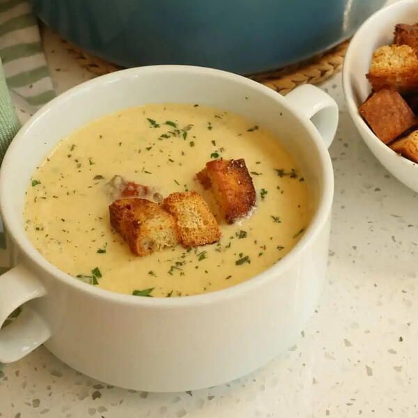 two bowls of soup with croutons on the side