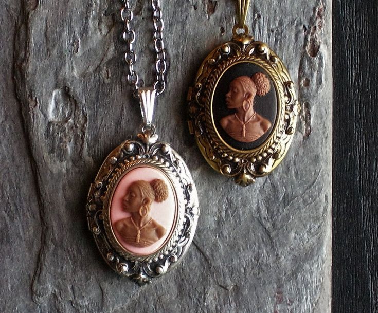 Detailed cameo set in detailed antique silver or antique brass on an antique silver or antique brass locket. Chain on the silver locket is gunmetal. Chain on the antique brass locket is also antique brass. Choose from a pink cameo or black cameo. Locket opens with two spaces for pictures. Details: Locket measures 1.25 inch x 7/8 inch Locket and chain are plated brass Gunmetal is shiny, dark grey plating Chain measures 18 inches Lead and nickel free Cameo is hard, matte resin You can find a numbe Antique Brass Cameo Locket Necklace, Vintage Medallion Cameo Locket Necklace, Antique Gold Cameo Medallion Locket Necklace, Bronze Cameo Jewelry For Vintage Collection, Vintage Collection Cameo Medallion Locket Necklace, Vintage Cameo Oval Pendant Jewelry, Vintage Collection Medallion Cameo Locket Necklace, Brass Medallion Locket Necklace With Cameo, Elegant Bronze Cameo Jewelry