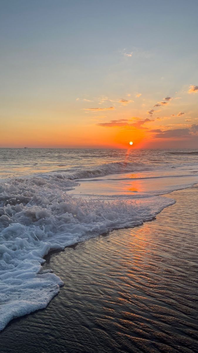 the sun is setting over the ocean waves