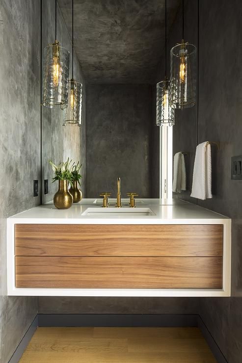 a bathroom with a sink, mirror and lights on the wall in front of it