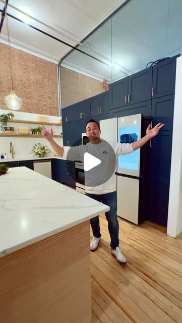 a man is standing in the middle of a kitchen with his hands out to someone