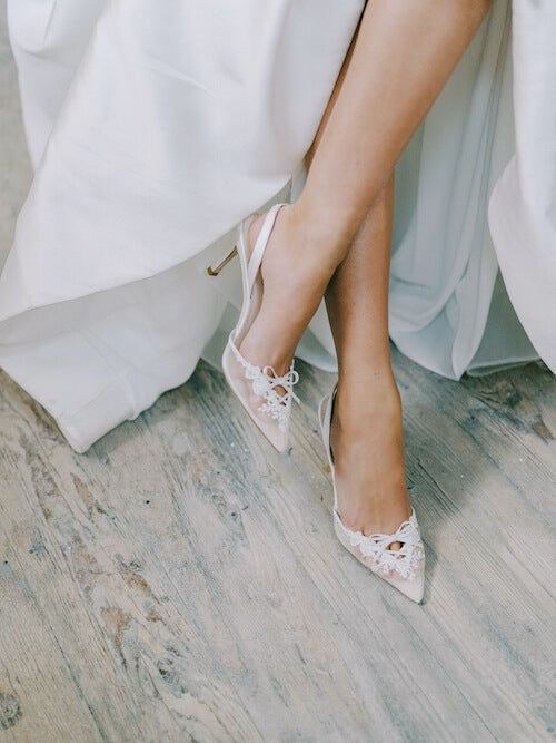 the bride's shoes are all white and have lace on them, while her dress is