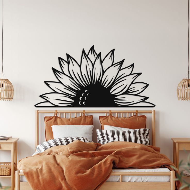 a bed sitting under a black and white sunflower wall decal