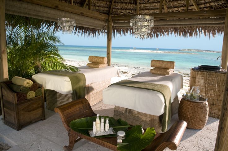 a couple of beds sitting on top of a sandy beach