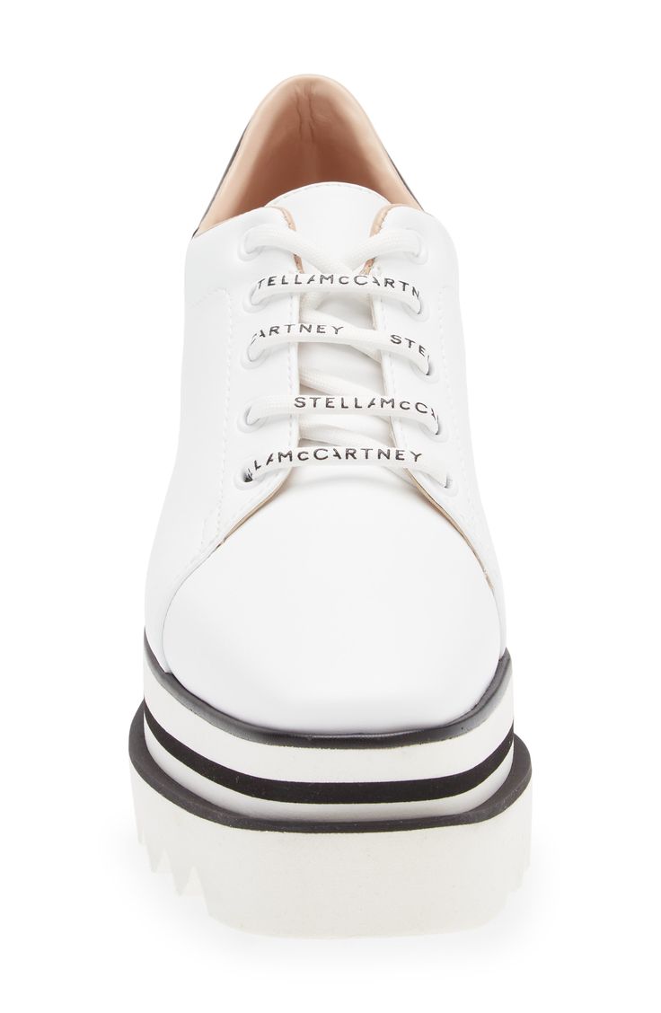 A sporty faux-leather sneaker from Stella McCartney features a perforated-logo at the heel collar, a chunky, striped platform and a sawtooth-edged rubber sole. 3 1/2" (89mm) heel; 2 1/2" platform (size 8.5US / 38.5EU) Synthetic upper, lining and sole Made in Spain Women's Designer Shoes Modern White Wedge Sneakers With Contrast Sole, Modern White Wedge Sneakers With Rubber Sole, White Leather Lace-up Wedge Sneakers, White Lace-up Wedge Sneakers With Perforated Toe Box, White Lace-up Leather Wedge Sneakers, White Leather Round Toe Wedge Sneakers, Leather Sporty Wedge Sneakers, Modern Leather Lace-up Wedge Sneakers, Leather Wedge Sneakers With Branded Insole