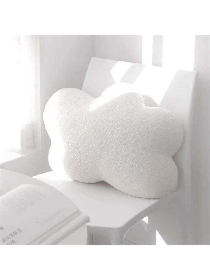 a pillow sitting on top of a white chair