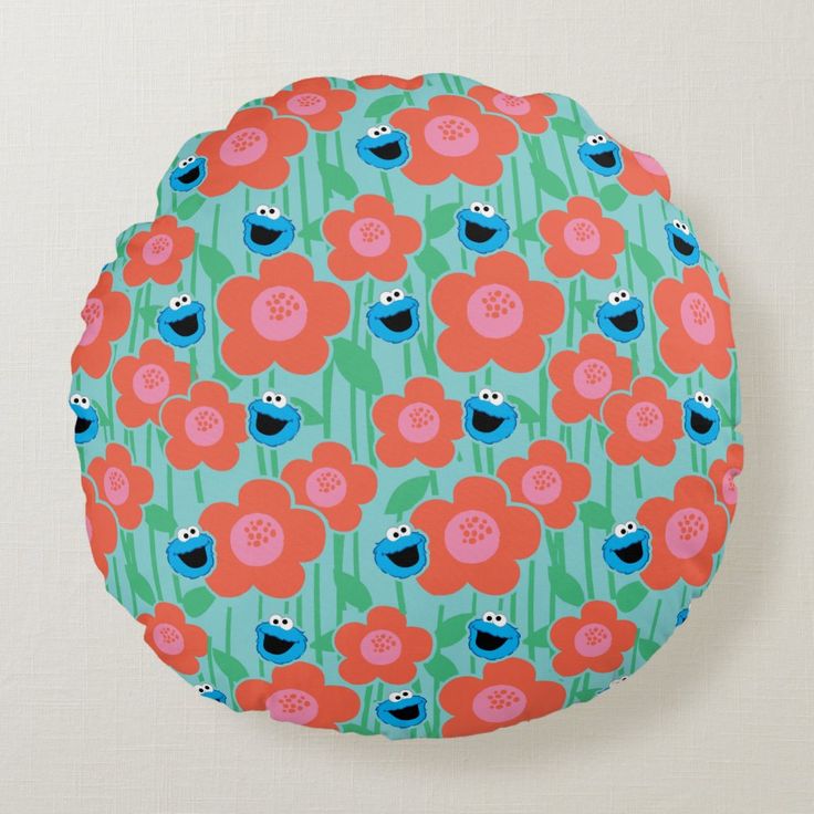 a round pillow with an image of sesame the cookie monster and red flowers on it