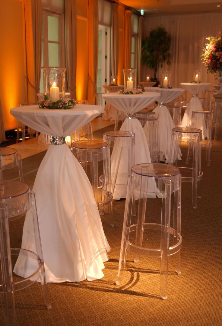 tables and chairs are set up with white cloths on them for an elegant function