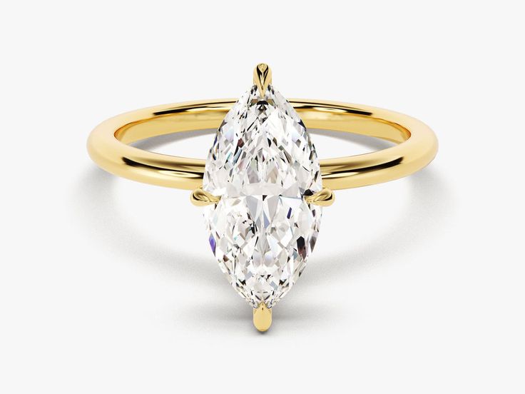 a yellow gold ring with a pear shaped diamond