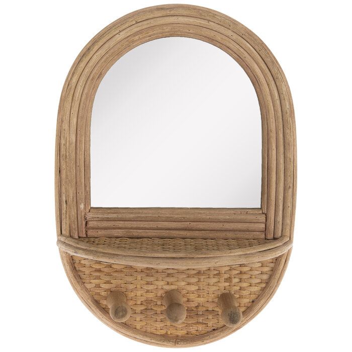 an oval wooden mirror with two hooks on the bottom and a shelf below it that holds a mirror