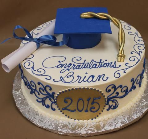 a graduation cake with a blue cap and diploma on top, decorated in white frosting