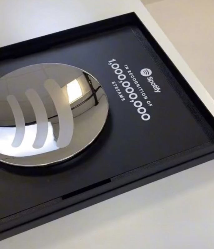 a metal object is on display in a black box with a white and silver logo