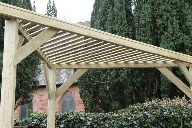 a wooden pergola in front of some trees