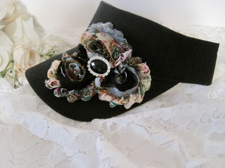 I designed this adorable black visor with beautiful matching variegated shabby flowers. I added a beautiful black and rhinestone center accent. Visor has velcro back I also have more colors that I will be listing as well. See more hats and visor here: https://www.etsy.com/shop/theraggedyrose?ref=seller-platform-mcnav&section_id=10557807 Custom orders alway welcome. Thanks for visiting my shop. Adjustable Black Visor With Curved Brim, Black Adjustable Visor With Curved Brim, Vintage Black Costume Hats For Spring, Adjustable Black Hat Band For Spring, Adjustable Black Hat Bands For Spring, Black Visor With Curved Brim, One Size Fits Most, Black Hat Band For Spring, Adjustable Black Brimmed Mini Hat, Adjustable Brimmed Black Mini Hats