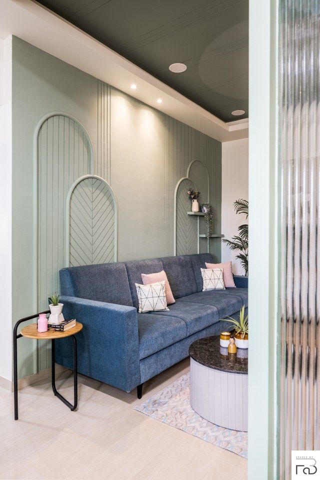 a living room with a blue couch and round coffee table in front of the wall