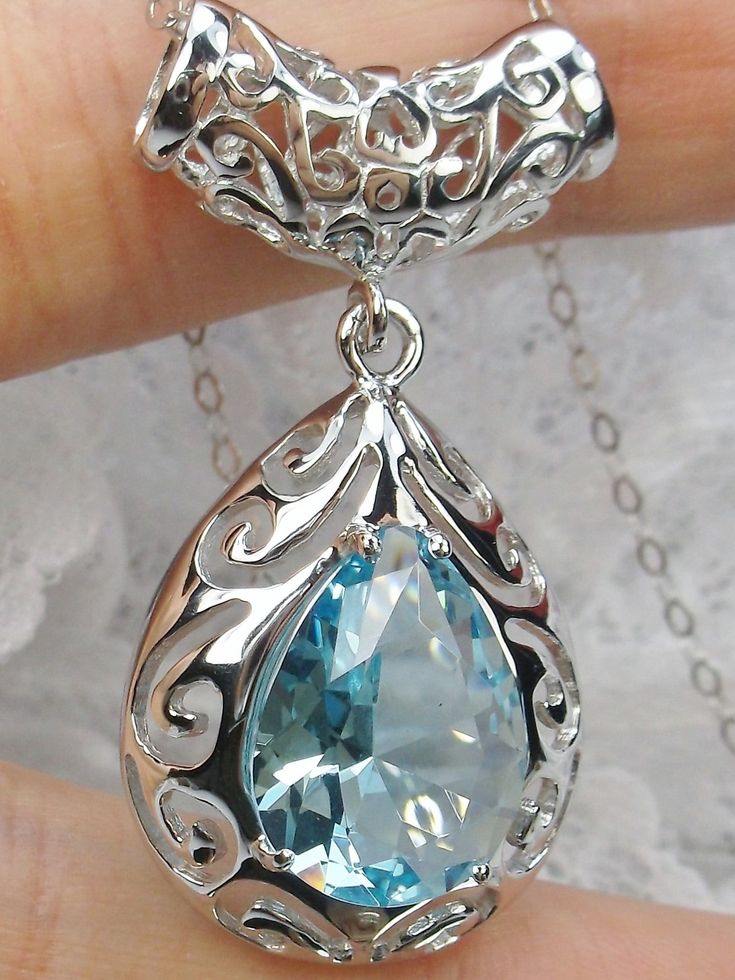 Simulated Sky-Blue Aquamarine PendantBig Teardrop Design#P28This is a stunning Victorian inspired pendant necklace. This beautiful necklace is handcrafted from sterling silver. The flawless 6 carat man-made aquamarine is a pear cut gemstone. Measurements are 16mm in length and 12mm in width. The 1.5mm sterling silver chain is 18" long (chain may be different than pictured). The entire pendant is 1-11/16" long by 13/16" wide. The pendant & necklace are marked 925 for sterling silver. Notice the b Pear-shaped Blue Topaz Gemstone Jewelry, Aquamarine Teardrop Jewelry For Formal Occasions, Teardrop Aquamarine Jewelry For Formal Occasions, Formal Teardrop Aquamarine Jewelry, Pear-shaped Blue Topaz Jewelry As A Gift, Pear-shaped Blue Topaz Jewelry For Gifts, Pear Shaped Blue Topaz Jewelry Gift, Pear Shaped Blue Topaz Jewelry For Gifts, Formal Blue Topaz Drop Necklace