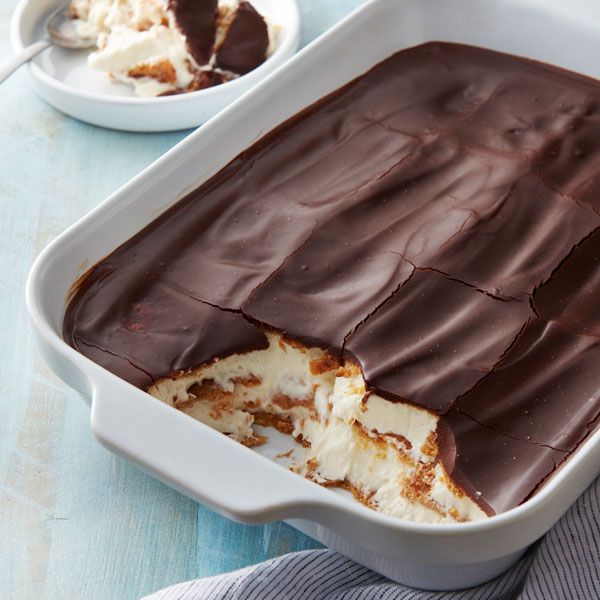 a cake in a white dish with chocolate frosting and ice cream on the side