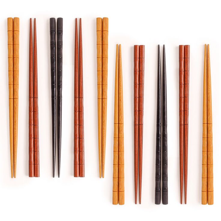 eight chopsticks lined up in a row on a white surface with black and brown handles