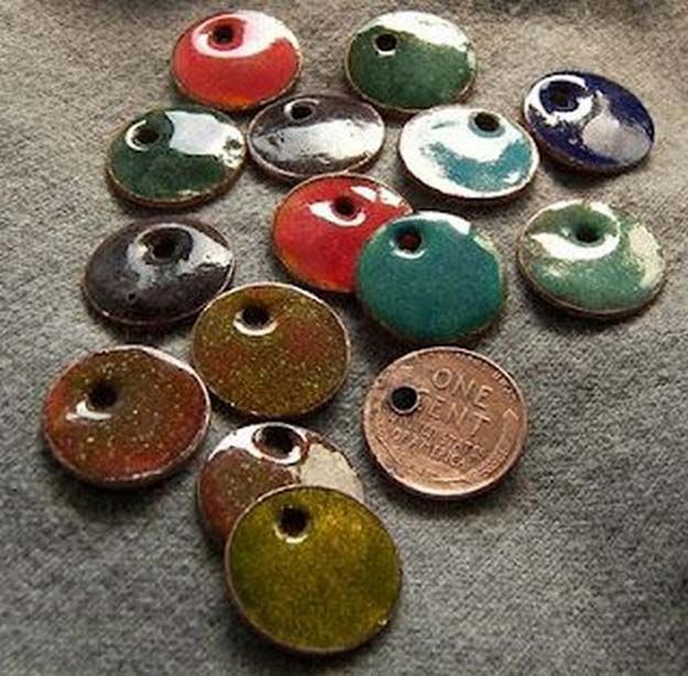 a pile of different colored buttons sitting on top of a gray cloth covered floor next to a penny