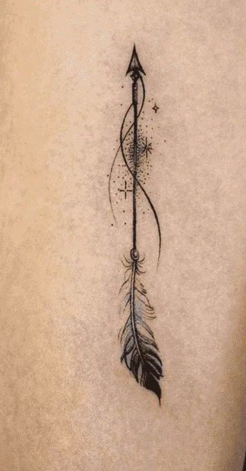 the back of a woman's stomach with an arrow and feathers tattoo on it