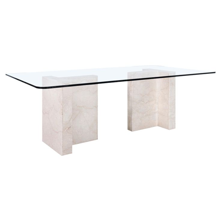 a glass and marble dining table with two white pillars on each end, against a white background