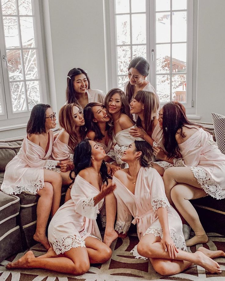 a group of women sitting on top of a couch next to each other in robes