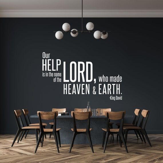 a dining room table with chairs and a wall decal above it that says our help lord, who made heaven & earth