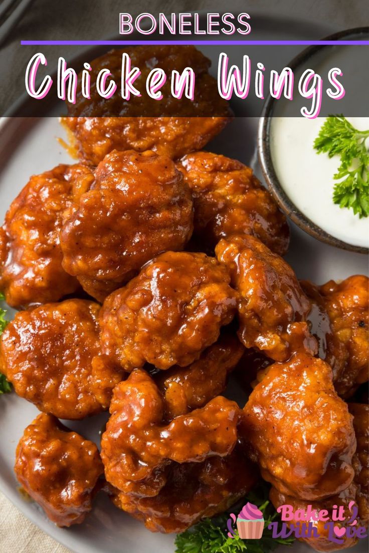 some chicken wings on a white plate with ranch sauce and parsley next to it